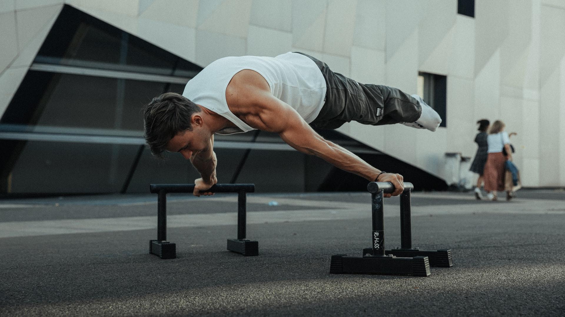 Mann trainiert Planking in Calisthenics Park