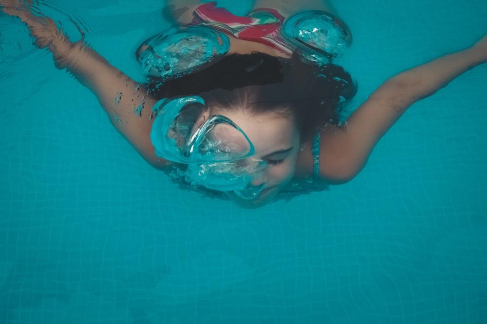 Mädchen taucht unter Wasser im Pool